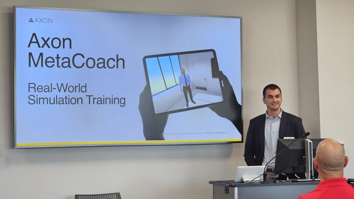 Axon presenter speaking at the podium during the August chapter meeting